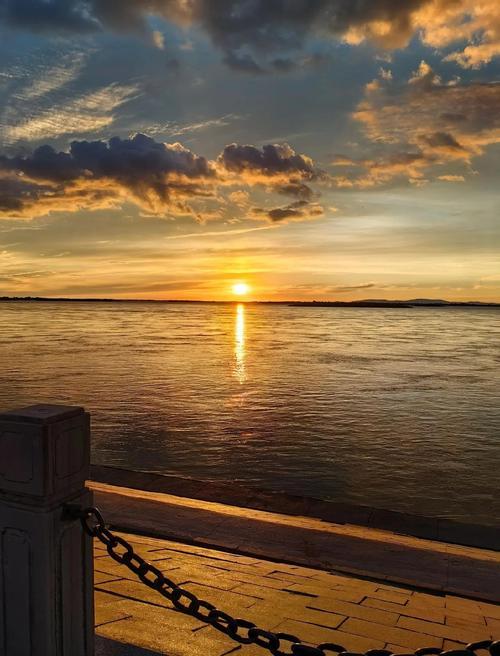 上联：晚霞落日映江流，上联：暮色归舟泊渡口，下联：早秋弯月立枝头。