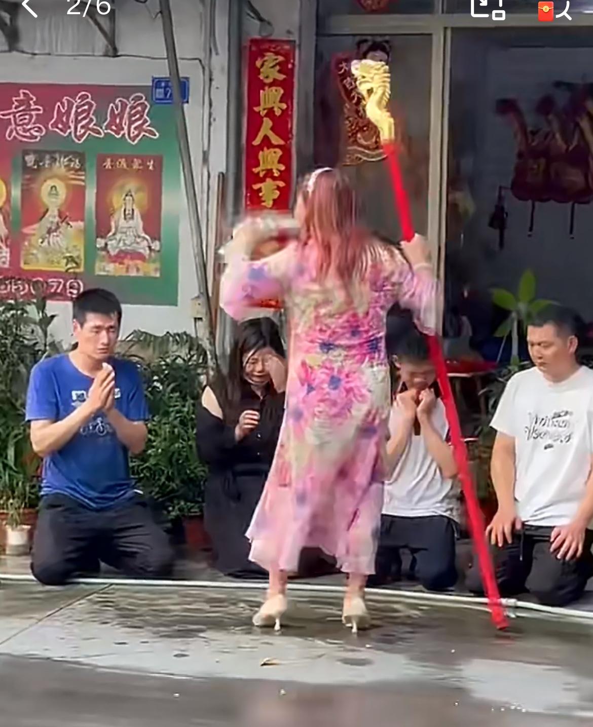 广东潮州一户门口跪着一家人，面前站着一个女人正对着他们做法事。原来这个女人是彩塘