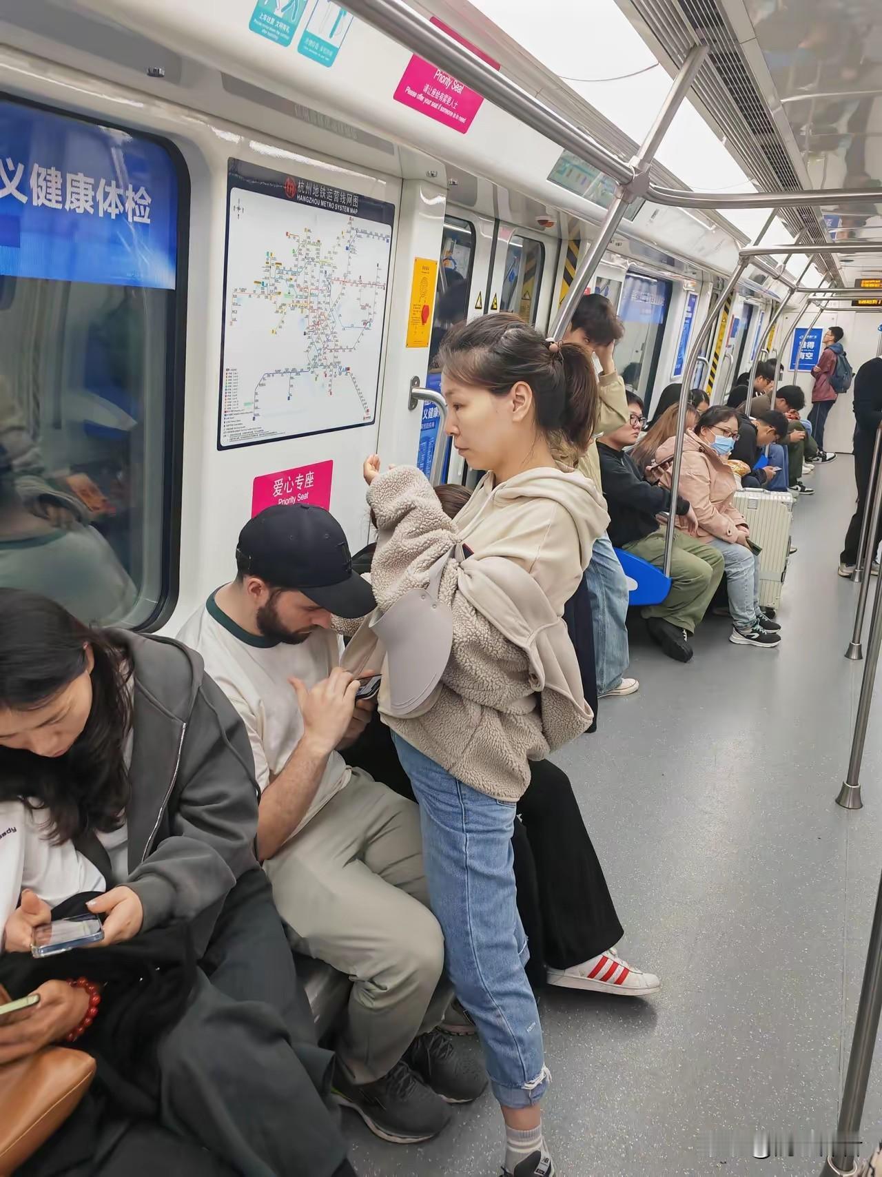 这中国姑娘宁愿自己站着也要让外国老公舒舒服服的坐着。这情景如果是发生在国内的夫妻