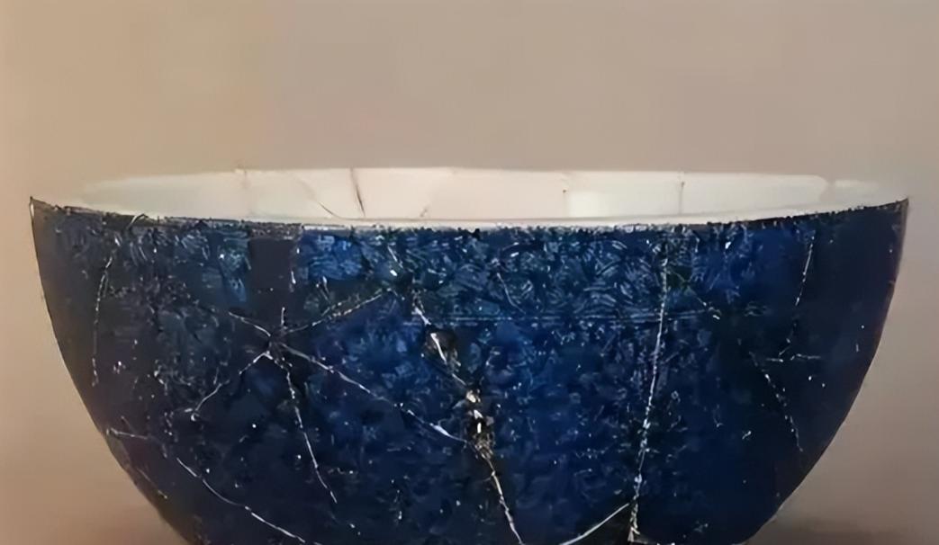 1972年，北京一清洁工清理着街上的一处公厕，由于许久未曾清理，老人家一手掩面，