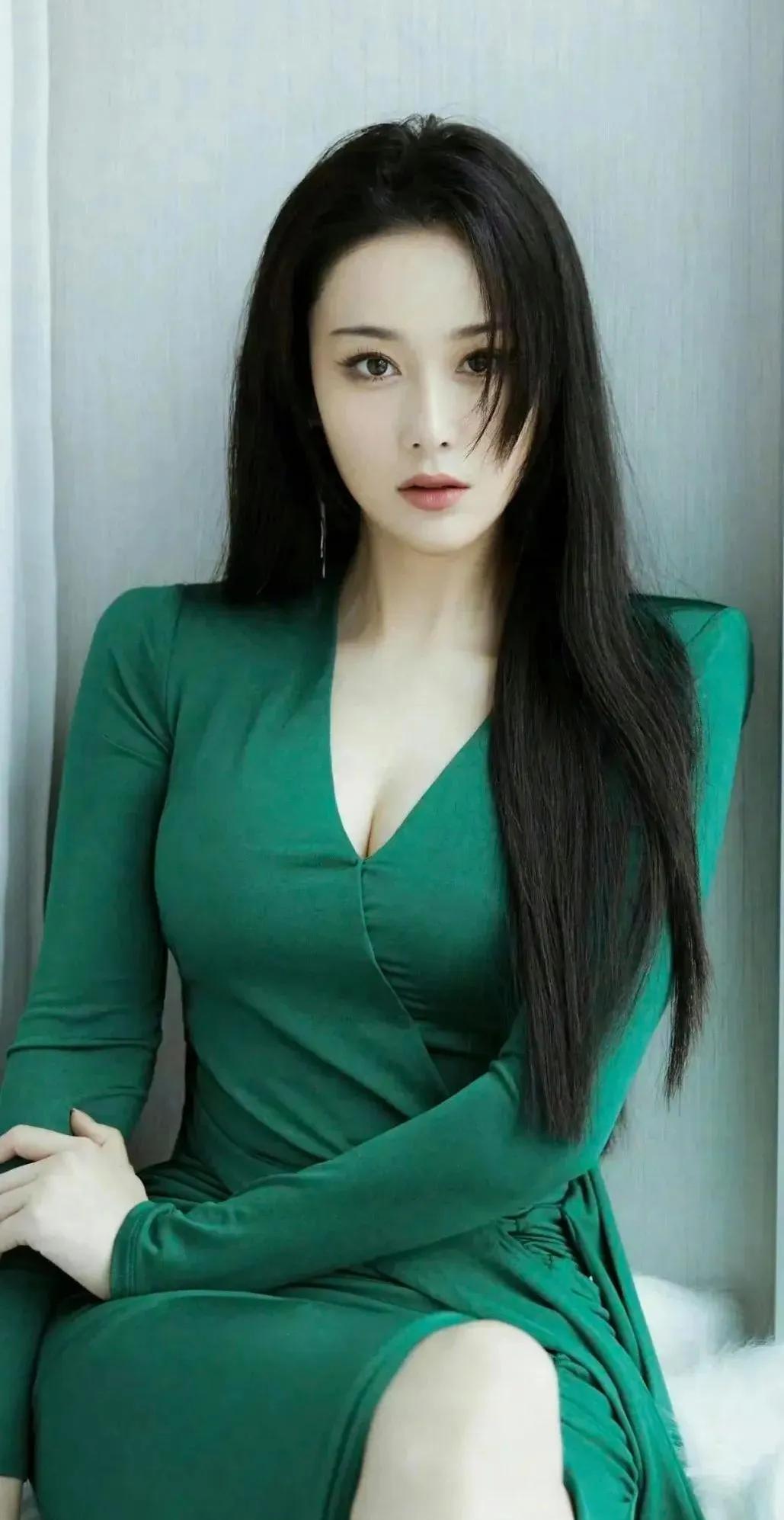 张馨予身着一袭墨绿色长裙，在纯白背景的衬托下，浓郁的绿像是从森林深处萃取而来，自