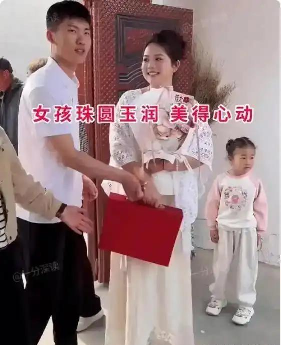 村里这场订婚仪式，在当地成了大家热议的话题。姑娘珠圆玉润，眉眼含笑，一身素