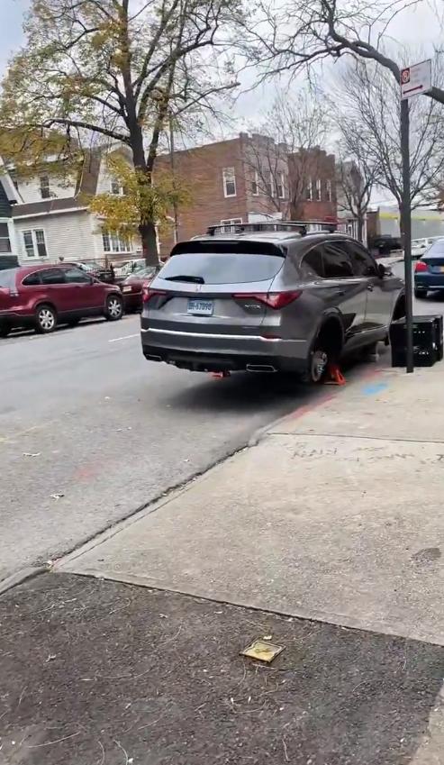 窃贼光天化日之下在纽约市一条居民街道上，明目张胆地偷窃一辆停放的灰色讴歌MDX