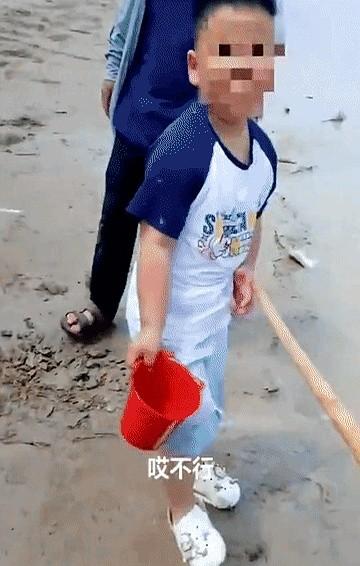 孩子河边玩命探头，老人放任不管，安全员赶忙拦阻。安全员指着河水讲掉下去的后果，