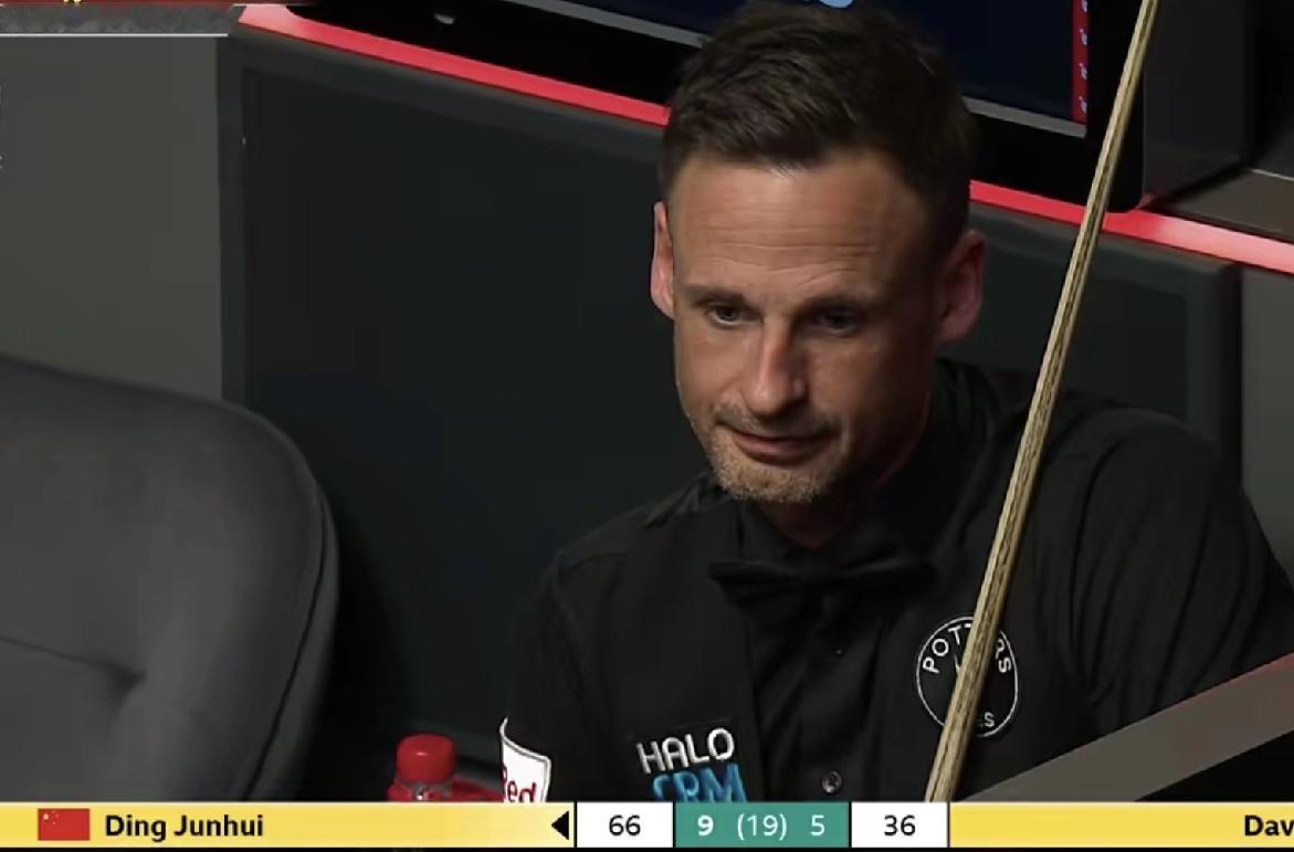 大卫·吉尔伯特的表情非常落寞。仿佛生无可恋。此时，是丁俊晖的赛点局，9：5领