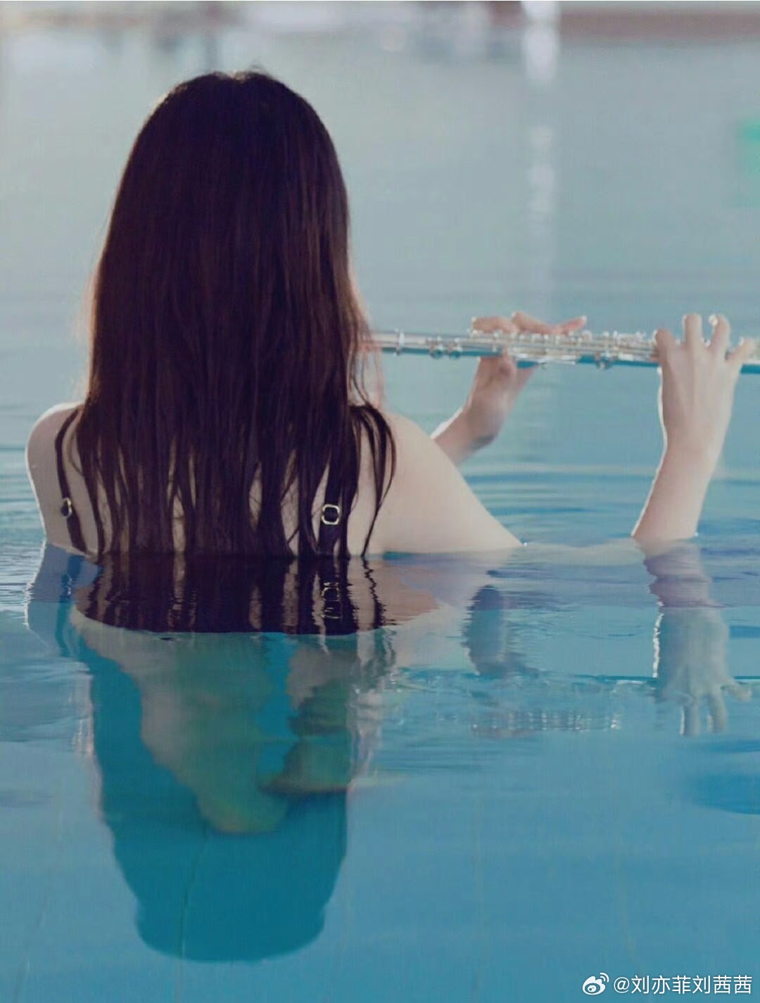 在这组画面中，刘亦菲身着简约黑色细肩带泳衣，线条利落，完美勾勒出流畅的肩颈与背部