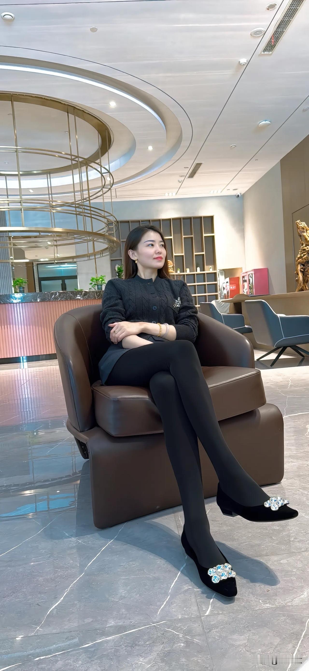 优雅黑衣女子，静坐现代客厅，品味生活之美。