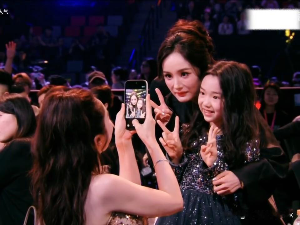 第一次见杨幂主动找人合影，还是找一个小朋友[呲牙笑]杨幂披着外套悄咪咪的就过去