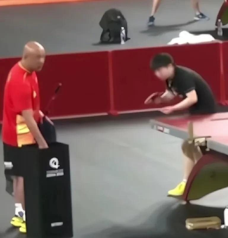 多哈训练场，肖指在和莎莎练球，莎莎停下看向大头方向回答说:穿那天那个!大头