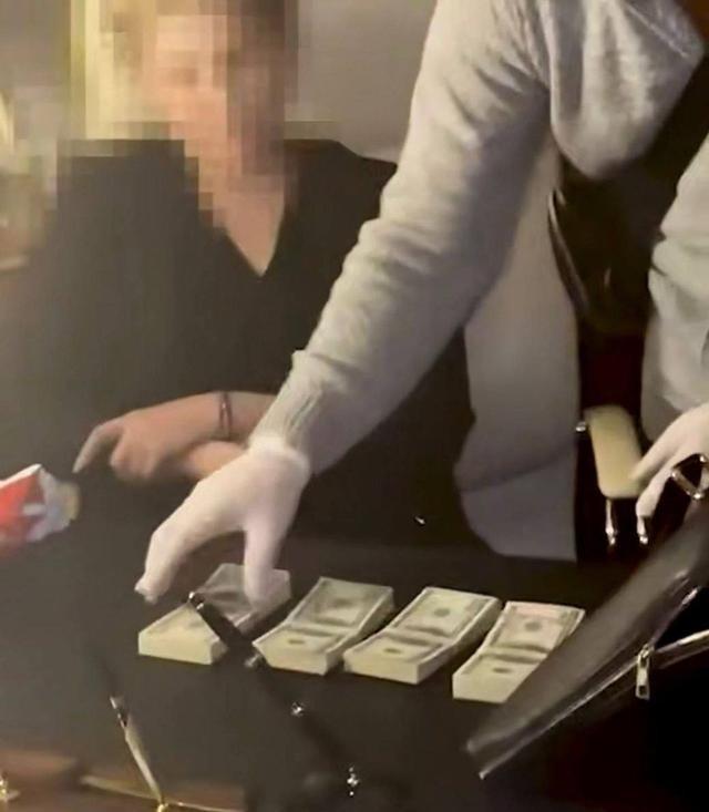 乌克兰国家安全局在对季莫申科办公室的搜查中，她的办公桌上明显放着几捆美元。据