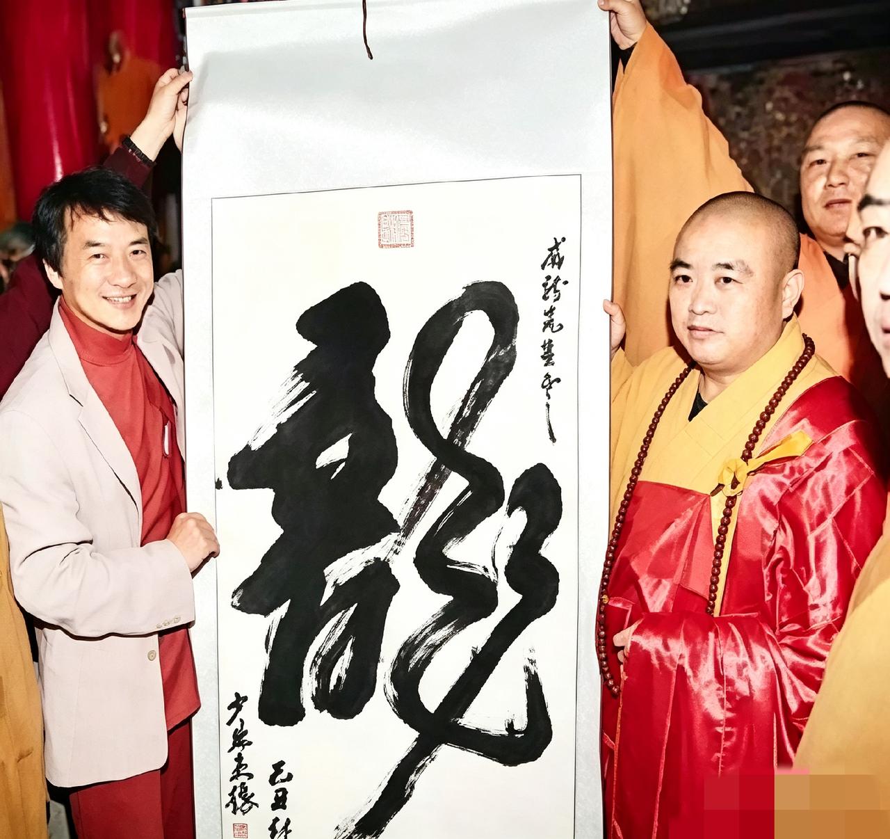 翻到张老照片。当年成龙去拜访，方丈顺手写了幅“龙”字相赠。俩人举着字笑得很开心。