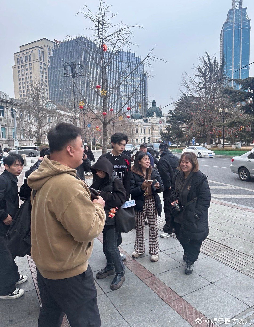 买烤冷面偶遇陈飞宇路透照里陈飞宇站在街边，旁边是烤冷面摊子，画面莫名有生活气息