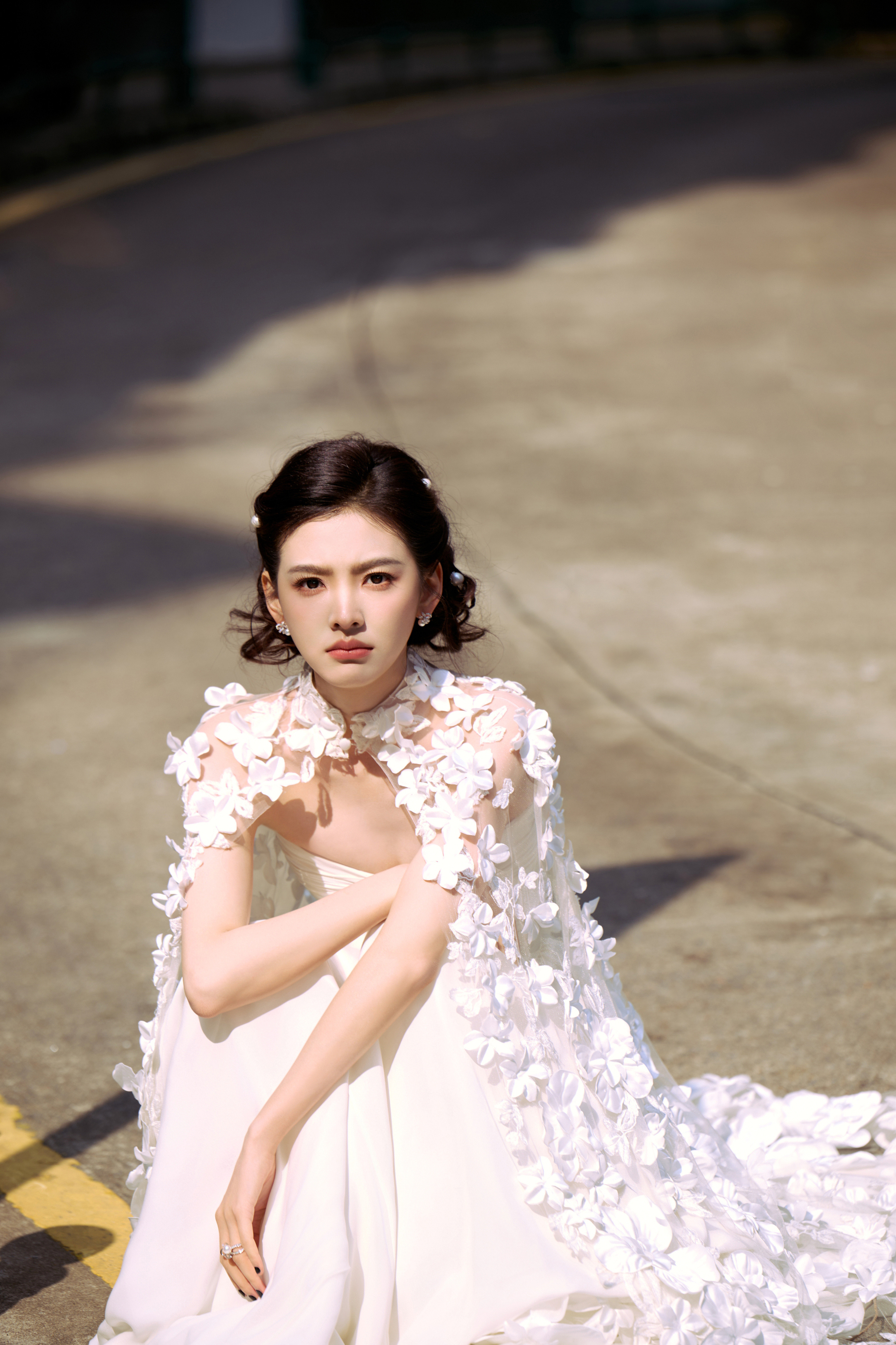 章若楠一袭极简白裙勾勒出流畅的肩颈线条，无袖抹胸设计利落又高级，垂坠的裙摆自