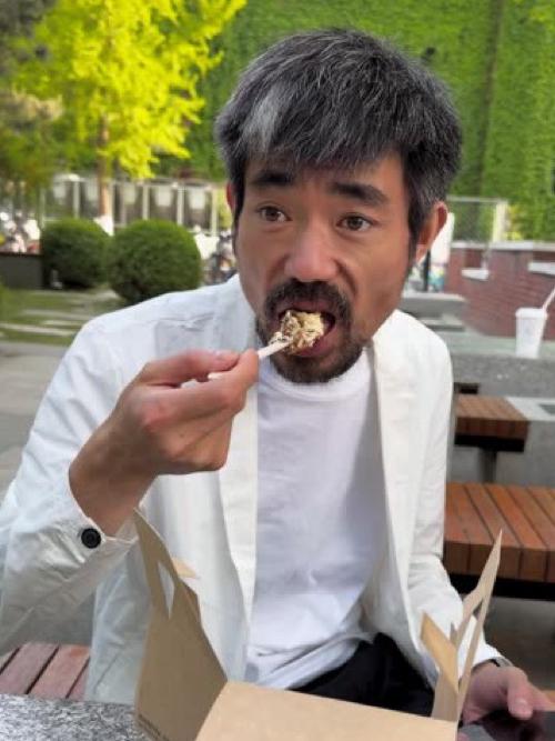 但现实里，他每天的戏，全靠饭店那扇旋转门当背景板。西装不穿，就搭在肩膀上，手插在
