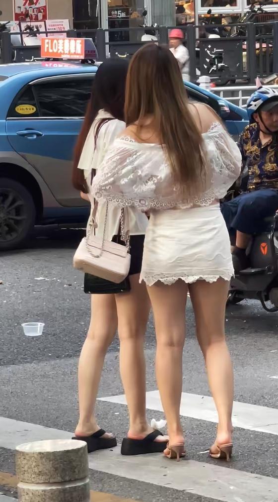 两姐妹秀美腿在逛马路。