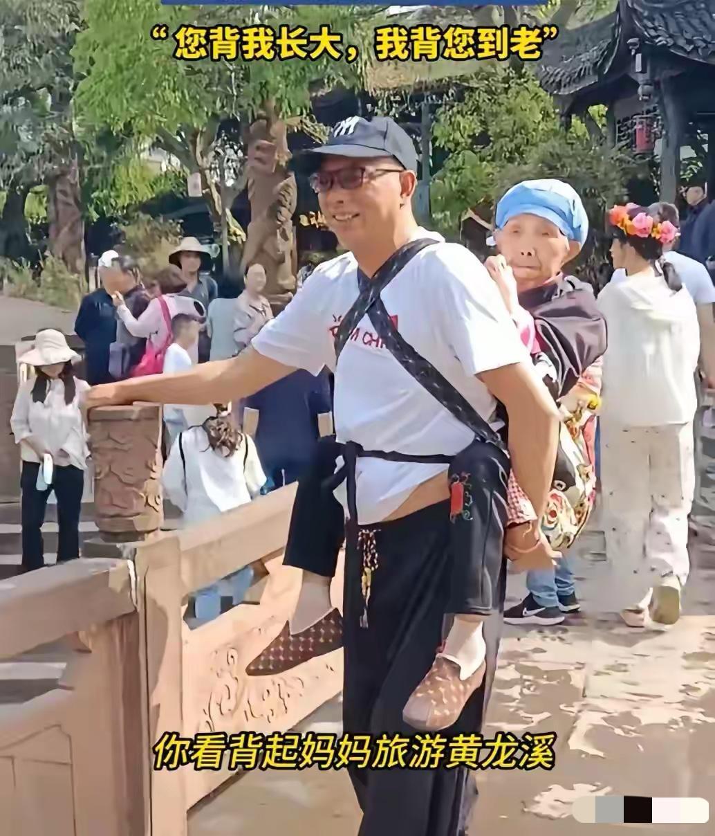 5月1日，四川黄龙溪风景区，有一位大叔背着年过九旬的老母亲游览，背上的母亲就像孩
