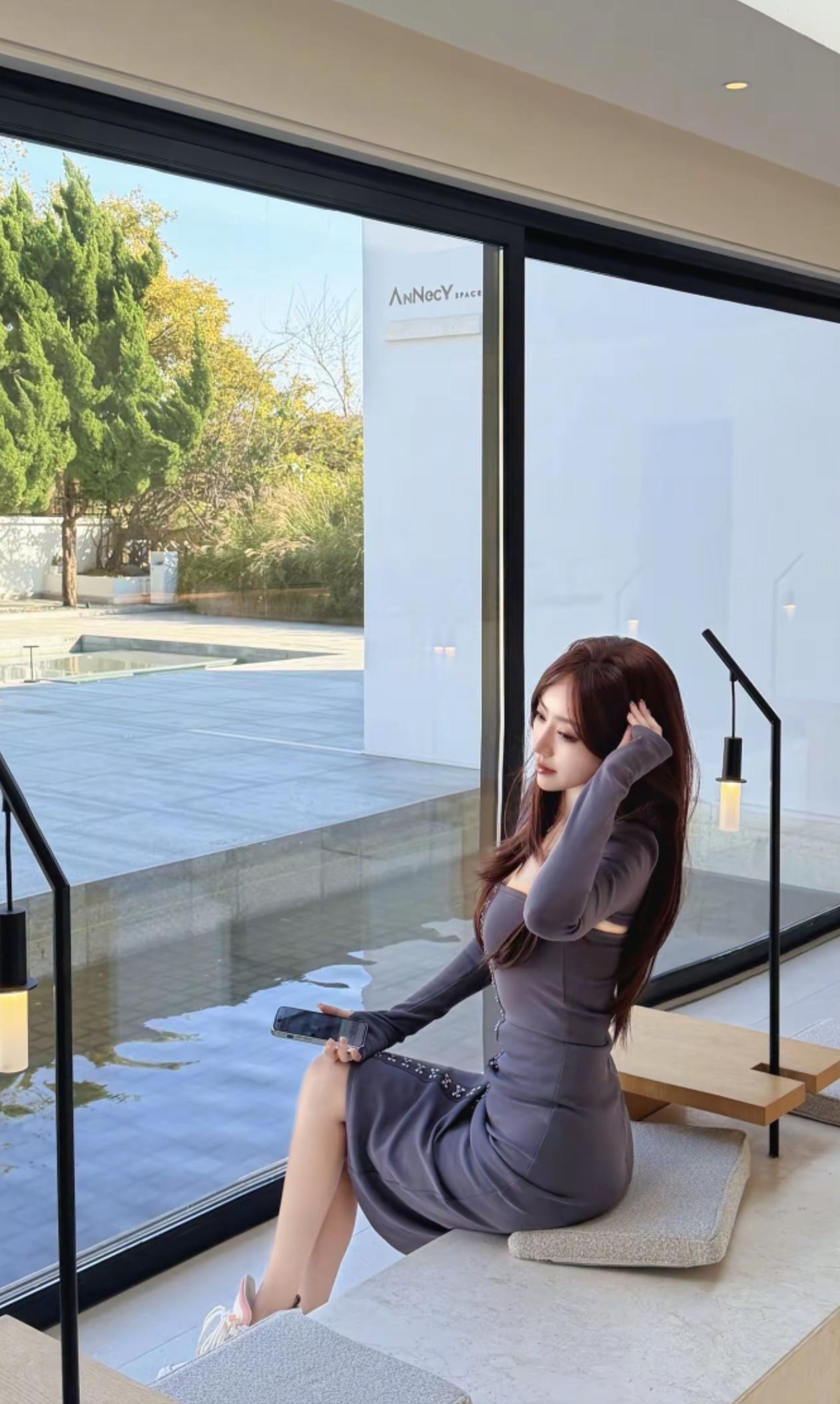 阳光洒进现代感十足的室内，时尚女孩在窗边享受悠闲时光。