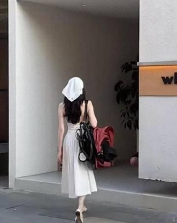 何穗阿那亚拍摄婴儿车广告，穿着挂脖白裙背着婴儿车，好像走T台