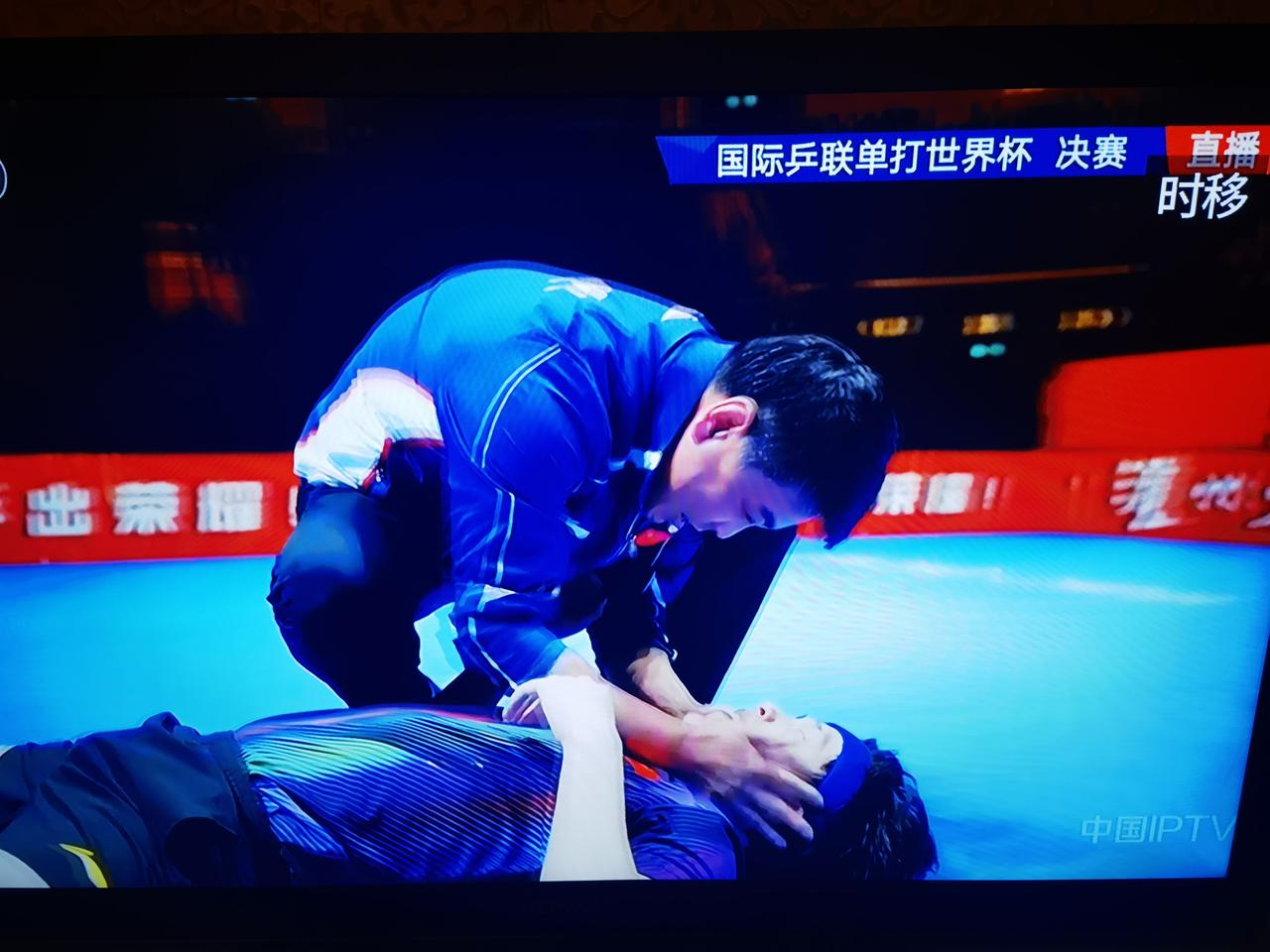 王楚钦赢了，倒地庆祝；王皓教练冲上去，跪在地上，摇着徒弟的肩膀，笑着喊着王楚