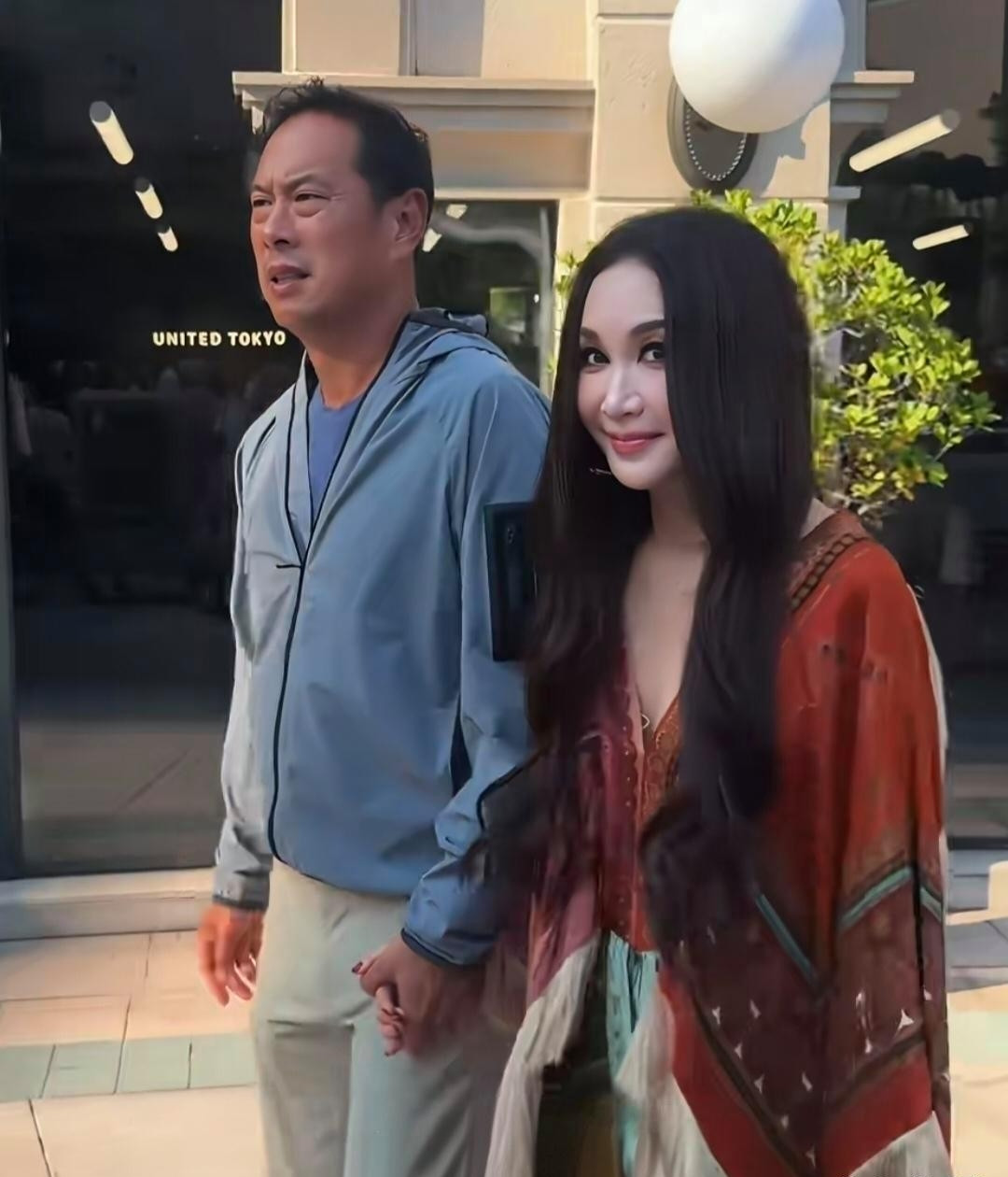 温碧霞和富商老公何祖光在香港街头被偶遇，两人手牵手，那叫一个恩爱！都60岁的温碧霞，穿着波西米亚风衣