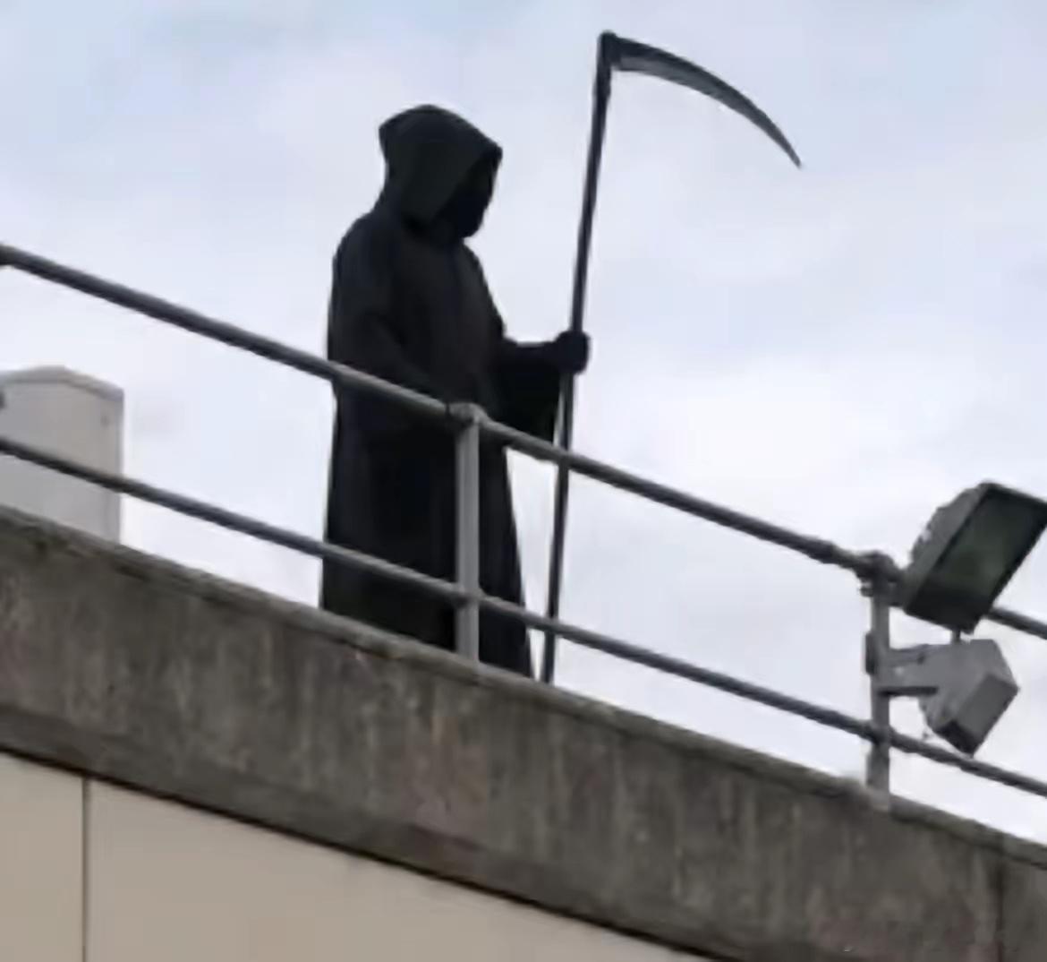 人在干坏事的时候是不会无聊的，一名英国男子假扮“死神”站在天台，对着医院的病人看