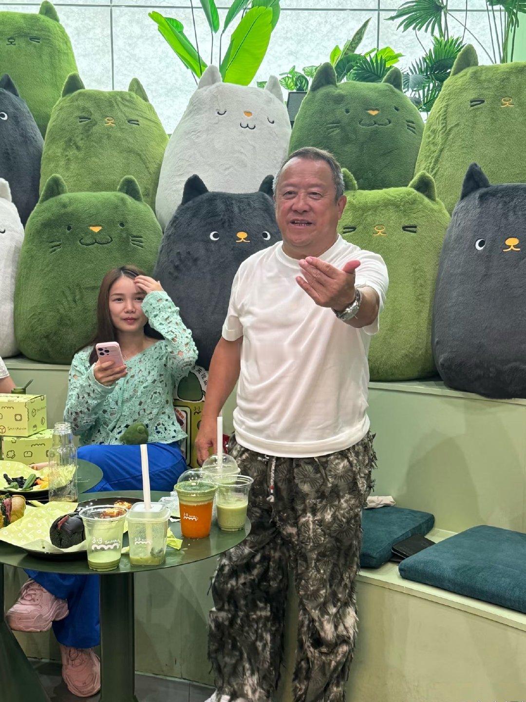 73岁曾志伟在广东一奶茶店被偶遇，身材圆润、桌子上摆了五杯奶茶，旁边的美女是他朋友吗​