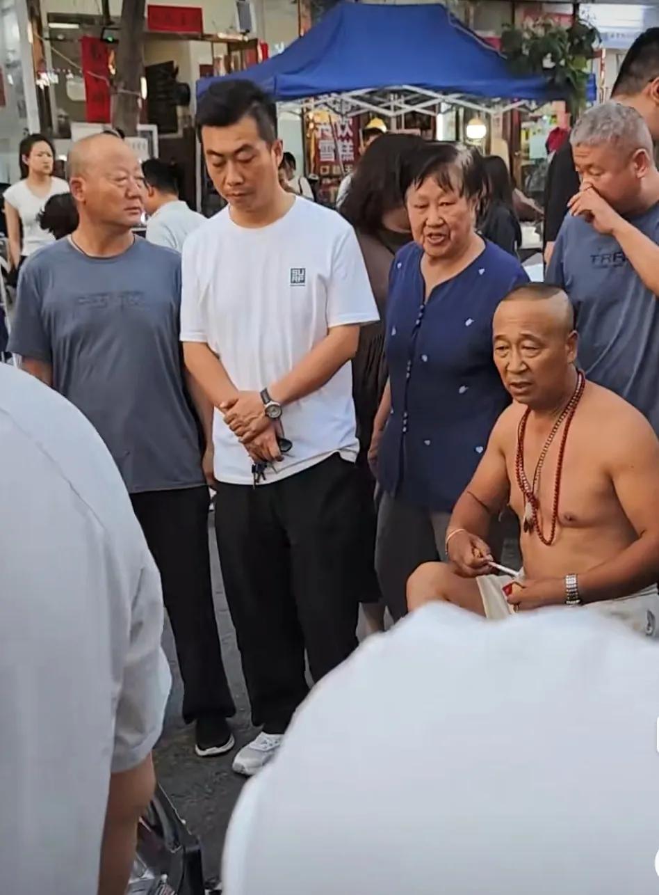 一只到处乱窜的狗被车撞死，一光膀子男拦住车，不让司机走，索要赔偿。关键是，他一没