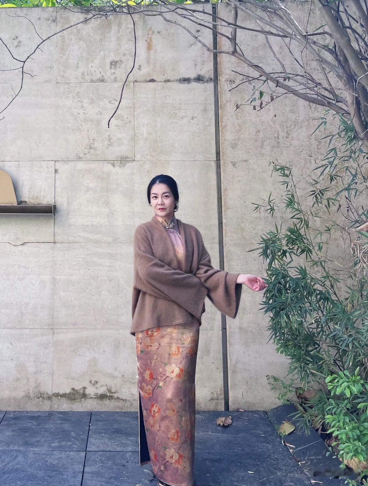 旗袍怎么样拍照有韵味穿着旗袍，手舞秋叶的优雅女子。