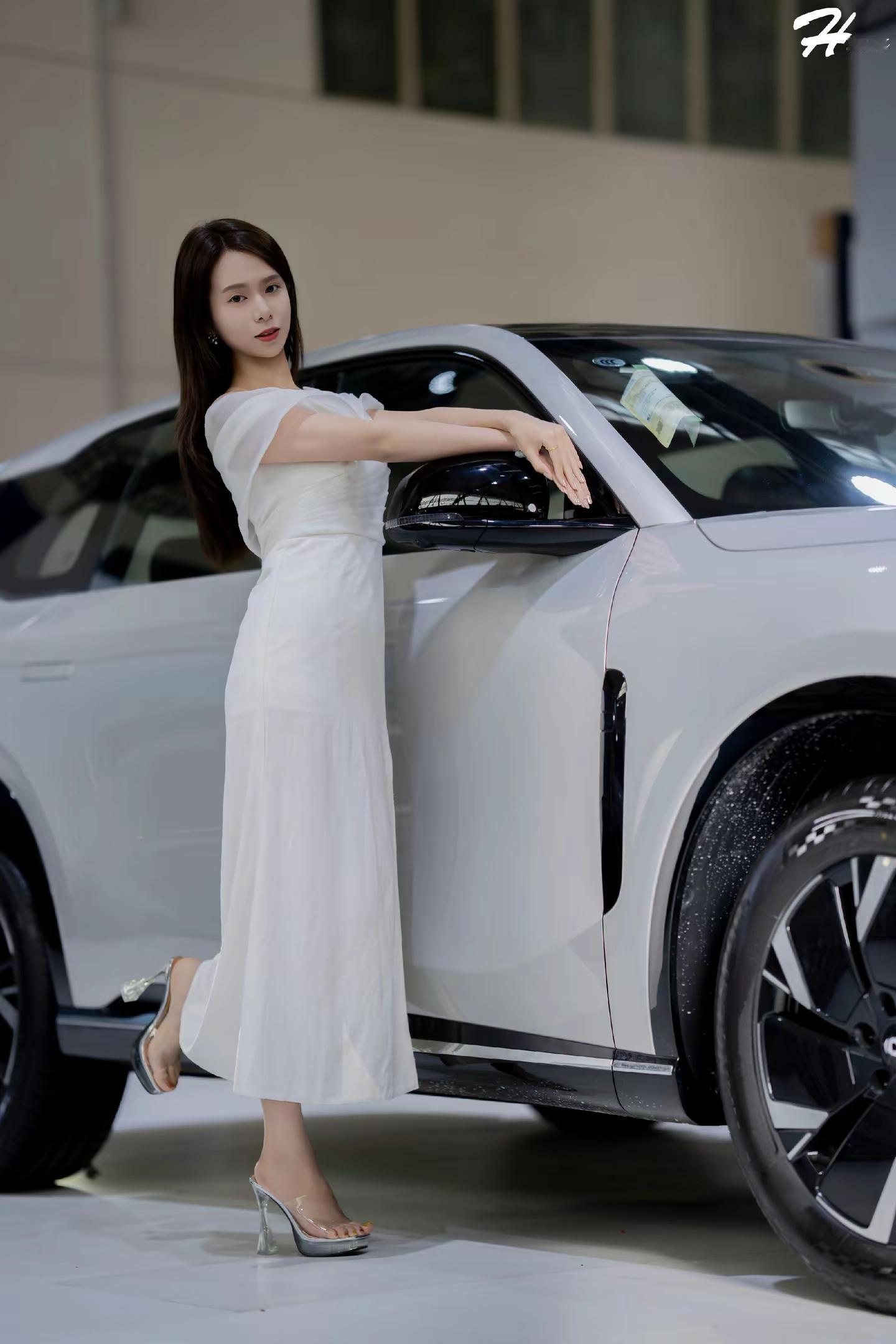 哈尔滨车展靓丽模特身穿白裙搭配着温柔注脚。模特一袭白裙衬得展厅都柔和下...