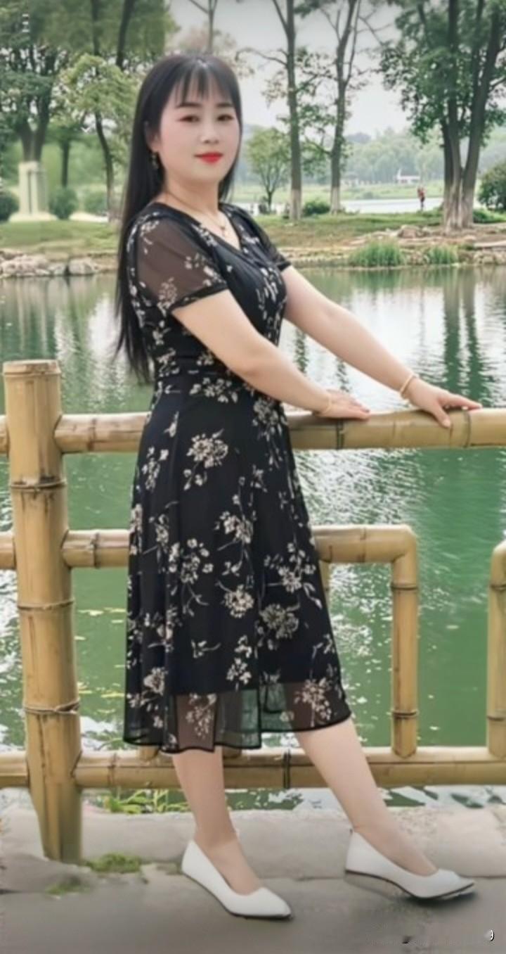 一位都市少女身着优雅黑裙，轻纱飘逸，来到静谧湖畔。如廖慧佳所展现的温婉，少女静坐
