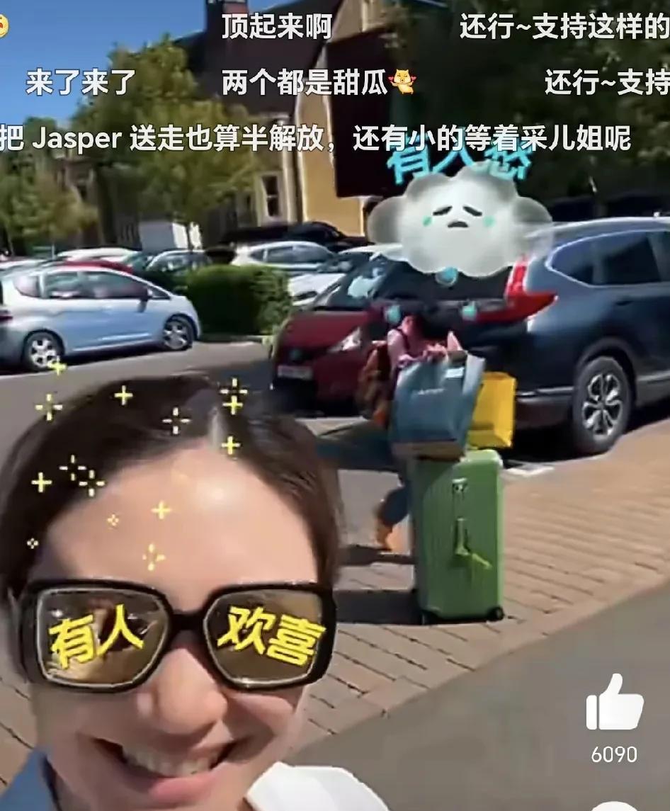 陈小春大儿子Jasper推着行李箱，一脸无奈的跟在应采儿身后，而应采儿则是开心的