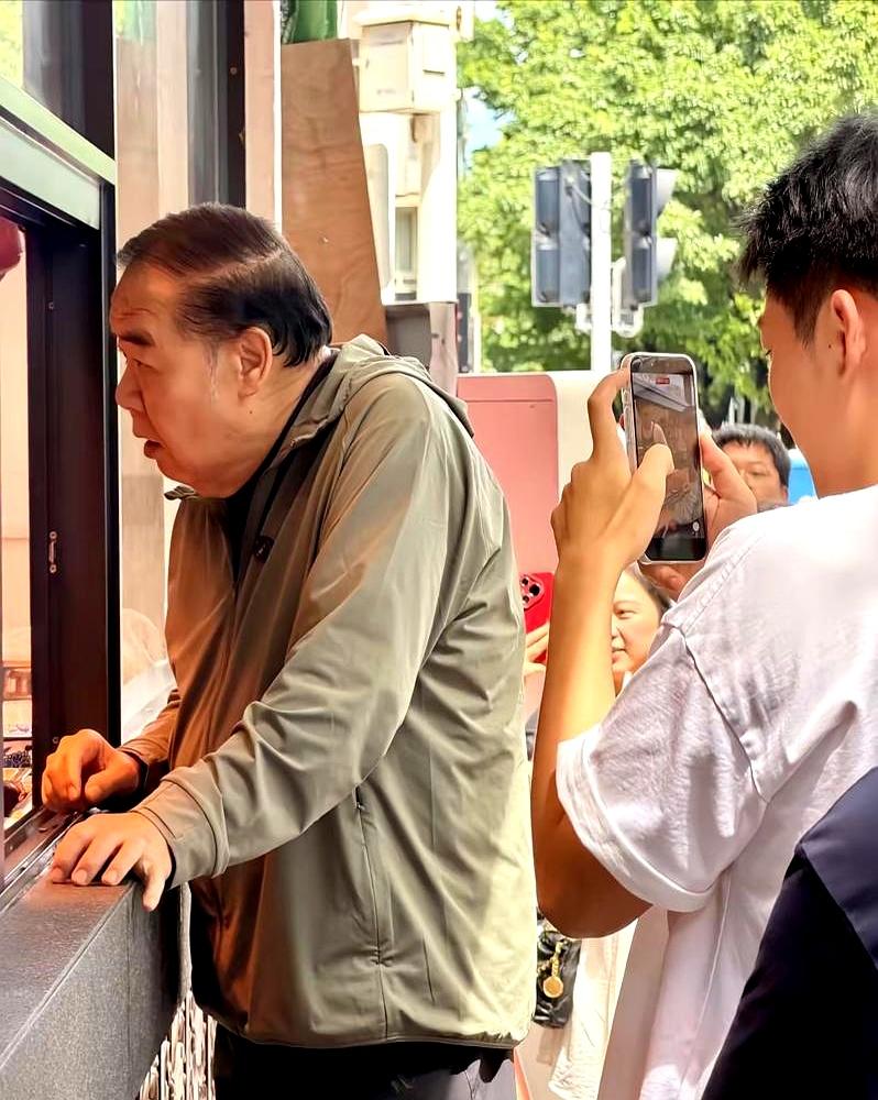汕头街头，75岁的郑则仕站在卤鹅摊前排队，旧T恤、细胳膊、整个人轻了不少，路人几