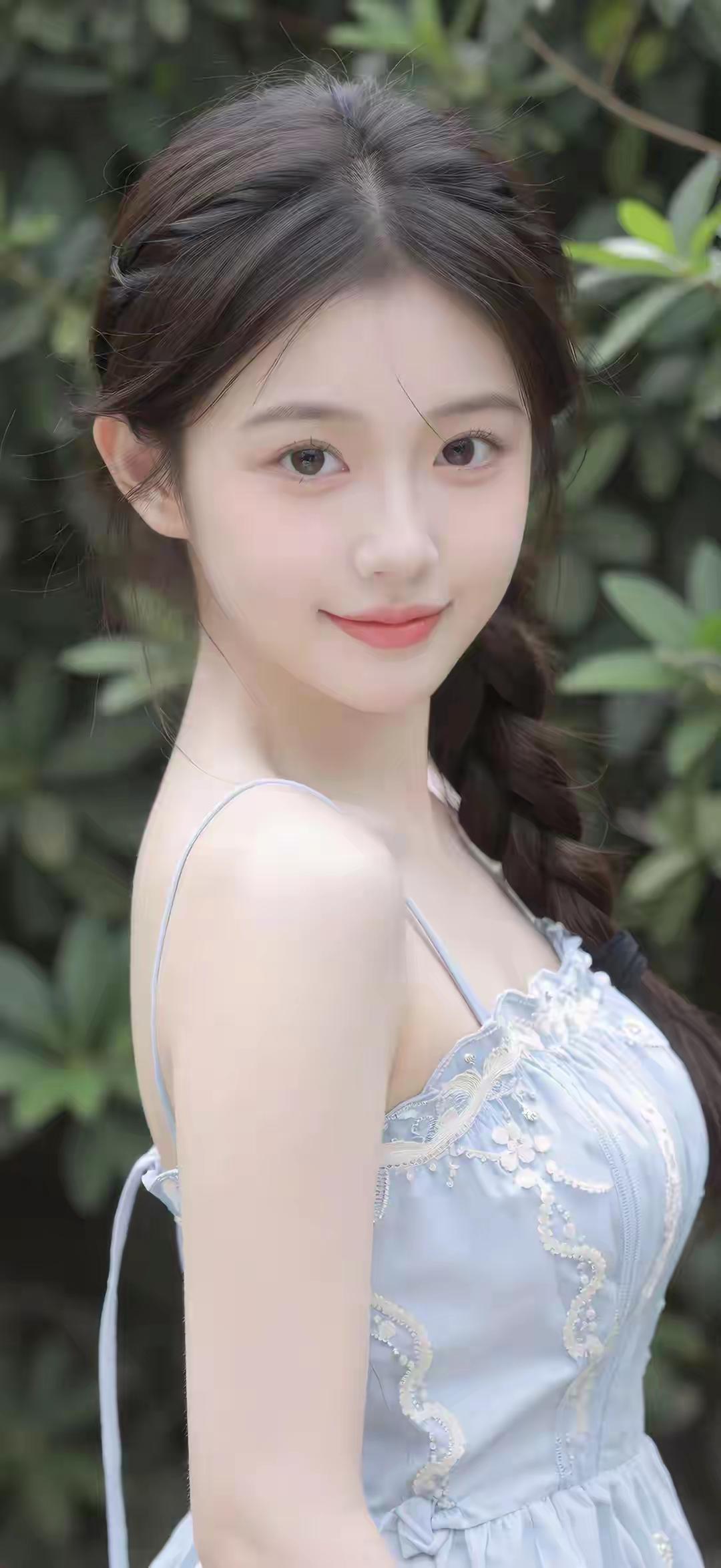 这位小姐姐穿着蓝色连衣裙，笑得很甜。迪士尼玩偶的吸引力为何这么大