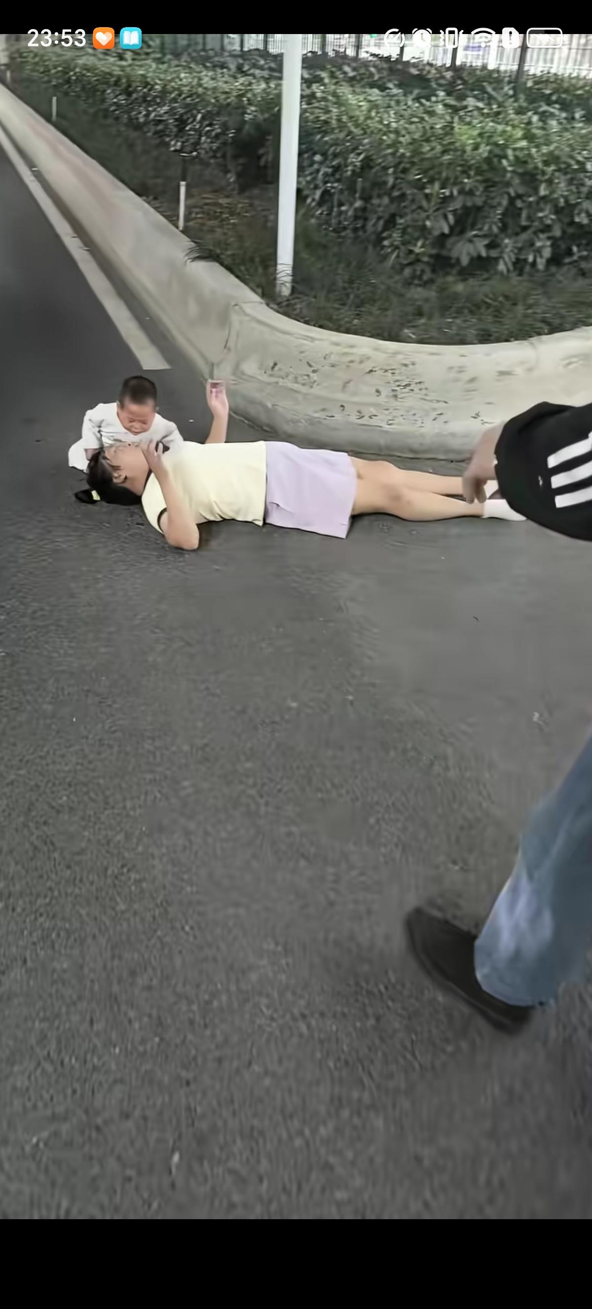 女子走在马路上就倒地上动弹不得了，她小小的儿子害怕的抱着妈妈哭，一好心男子路过先