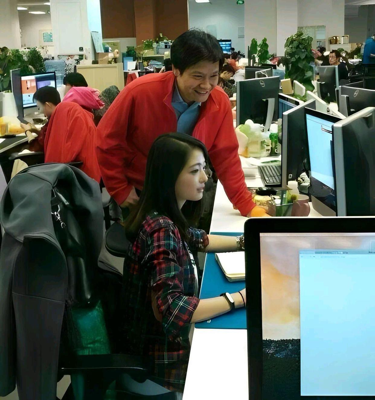 2014年，创业初期的雷军，与女工程师张功聊工作的一幕。张功作为小米早期的前