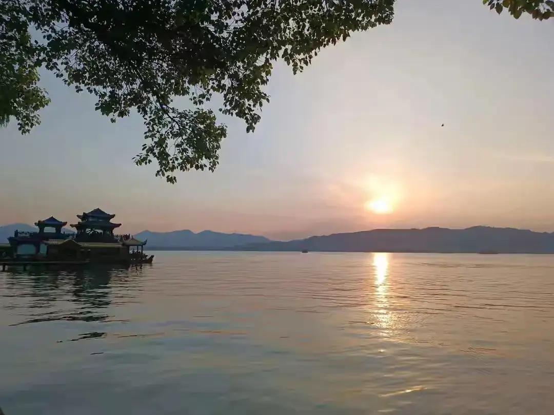 夕阳西下，静看那落日余晖照耀在西湖周边。就像我们在等一场岁月的流逝和等一场孤雁南