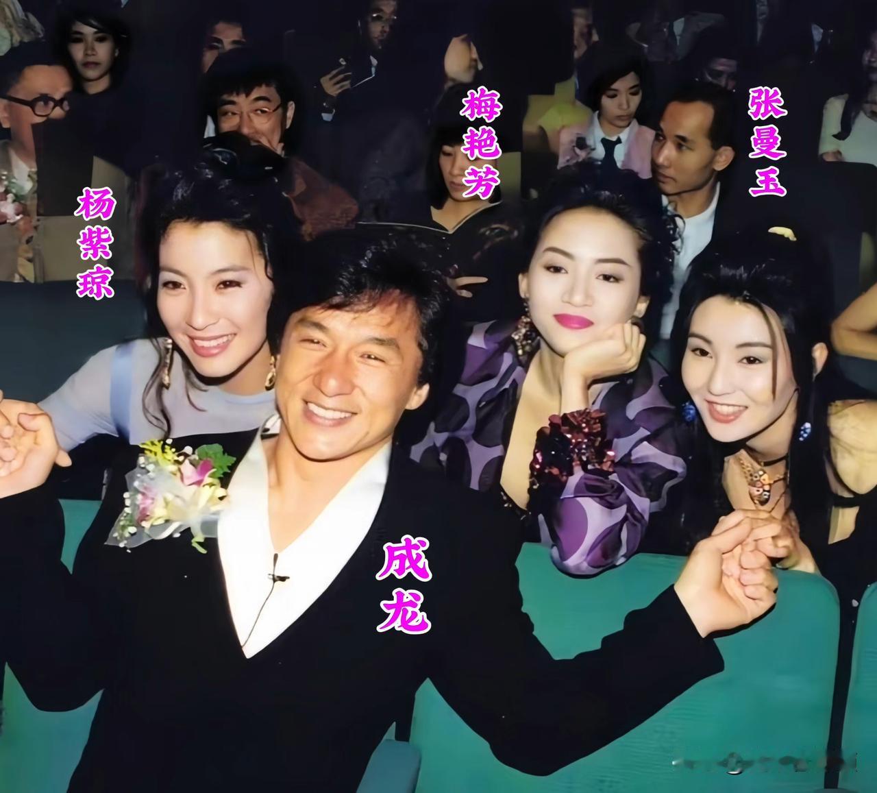 年轻时的成龙坐在C位，左手牵着张曼玉，右手牵着杨紫琼，梅艳芳安静倚靠在一旁。杨