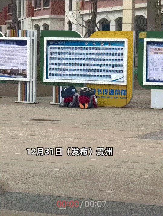 网上有个视频挺火的。说贵州一小学快期末了，两个小孩在操场的照片墙前跪下磕头，对着