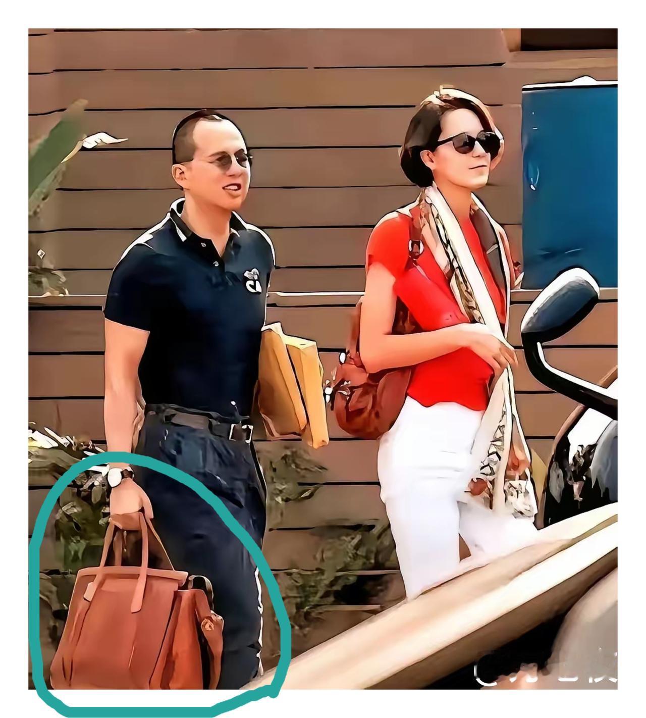 李泽楷拎的这个包看起来蛮重的，他怎么也不让助理帮忙拿一下呢？