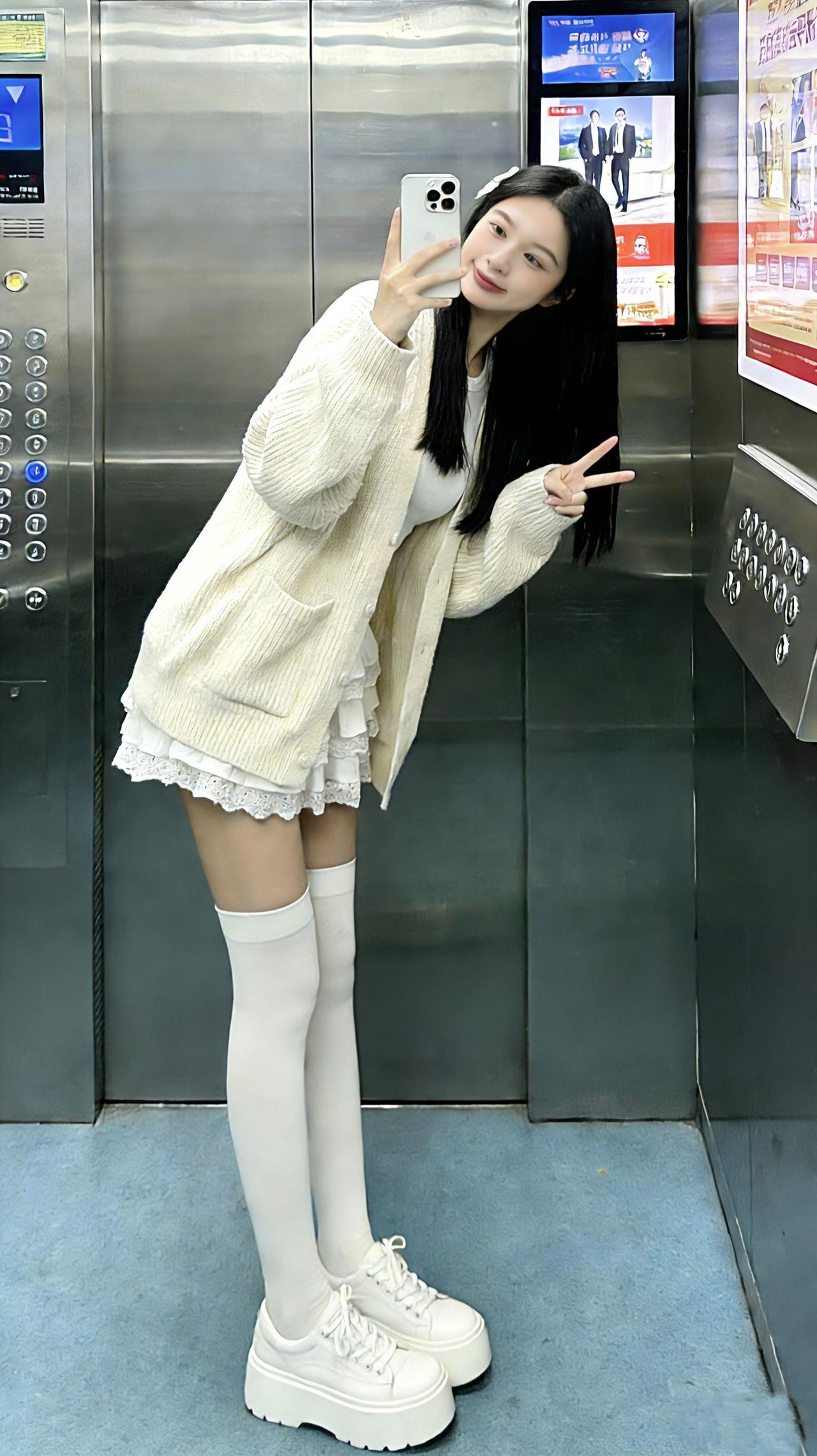 电梯间里，奶白针织裹着云朵般的软甜，蕾丝花边裙一摆像把温柔揉进了穿搭里～过膝白袜