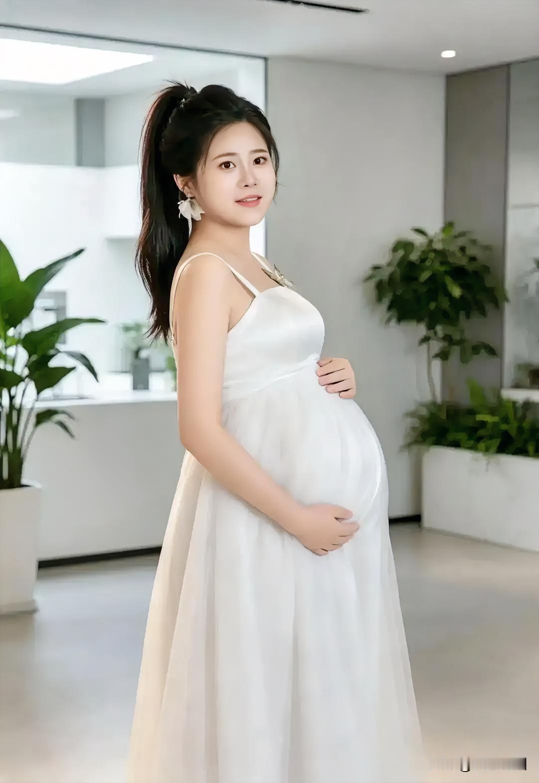 孕妇穿着白裙，微笑着展示孕肚。