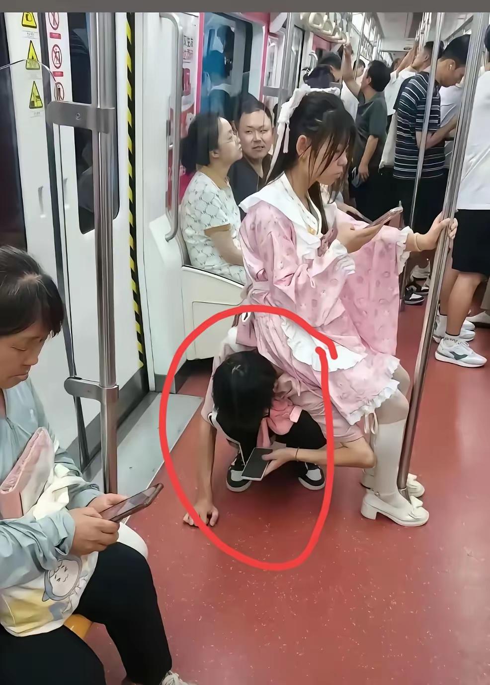 地铁上，一个男孩躬着腰蹲在地上给女孩当凳子！女孩毫无顾忌的一屁股坐到男孩身上，左