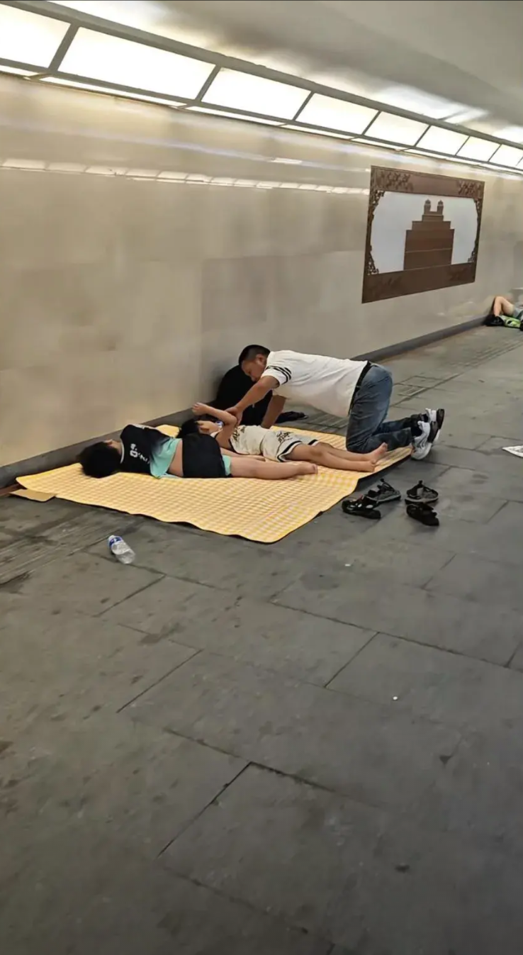 巡逻民警昨晚在地下通道愣住了。一家三口铺着凉席睡在通道拐角，父亲摇扇赶蚊子，