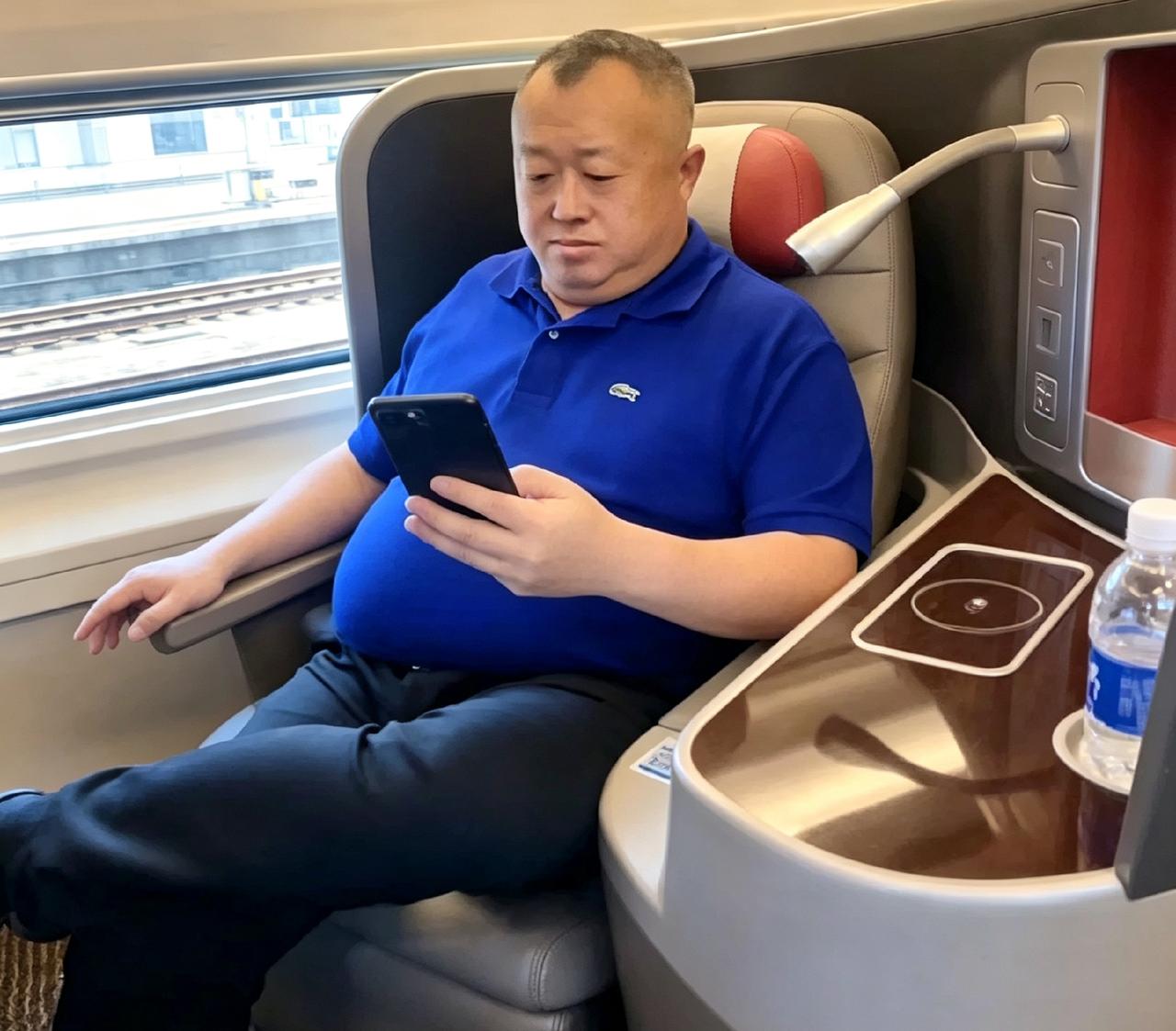 高铁上偶遇攀华集团李总。没前呼后拥，就穿件蓝Polo低头看手机。人家这么大老板，
