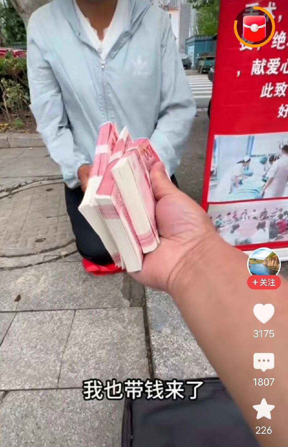 一名探店博主手里拿着3万元现金，递给跪在地上乞讨的女子，女子感恩戴德，刚想接住钱