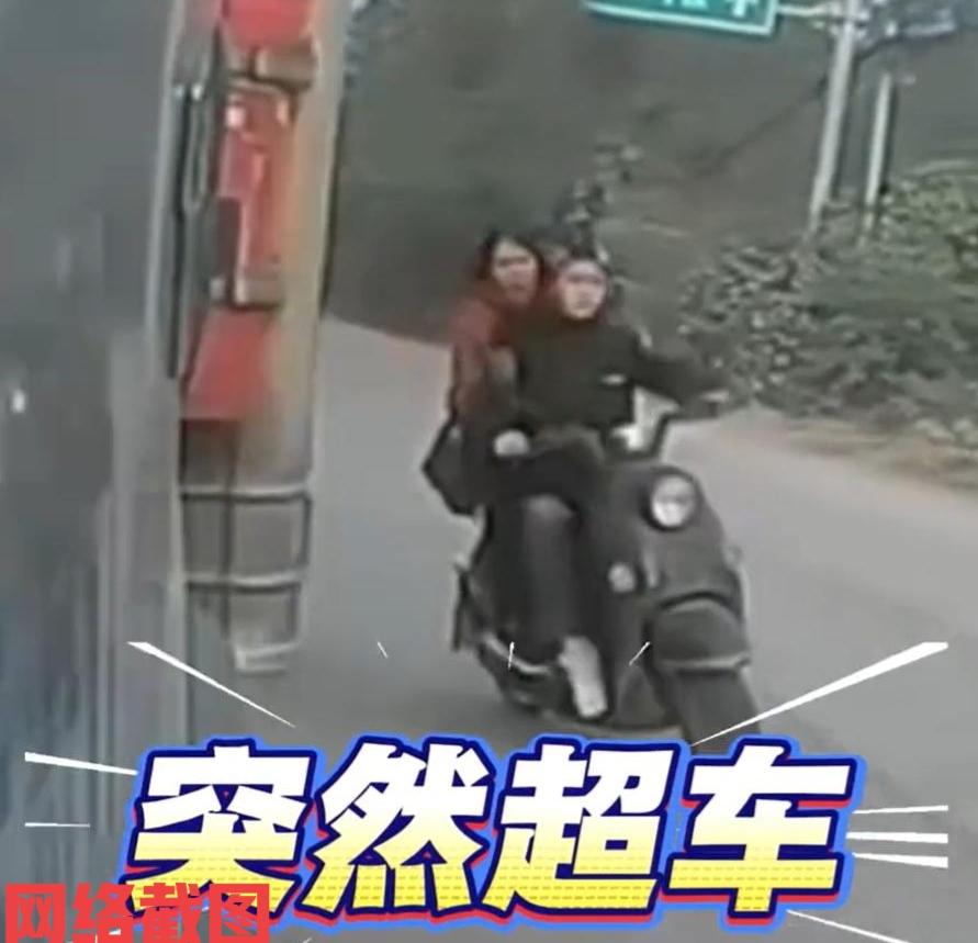 广西有女子开电瓶车还带人出行。此刻女子没戴头盔还想超前大货车。可想而知女