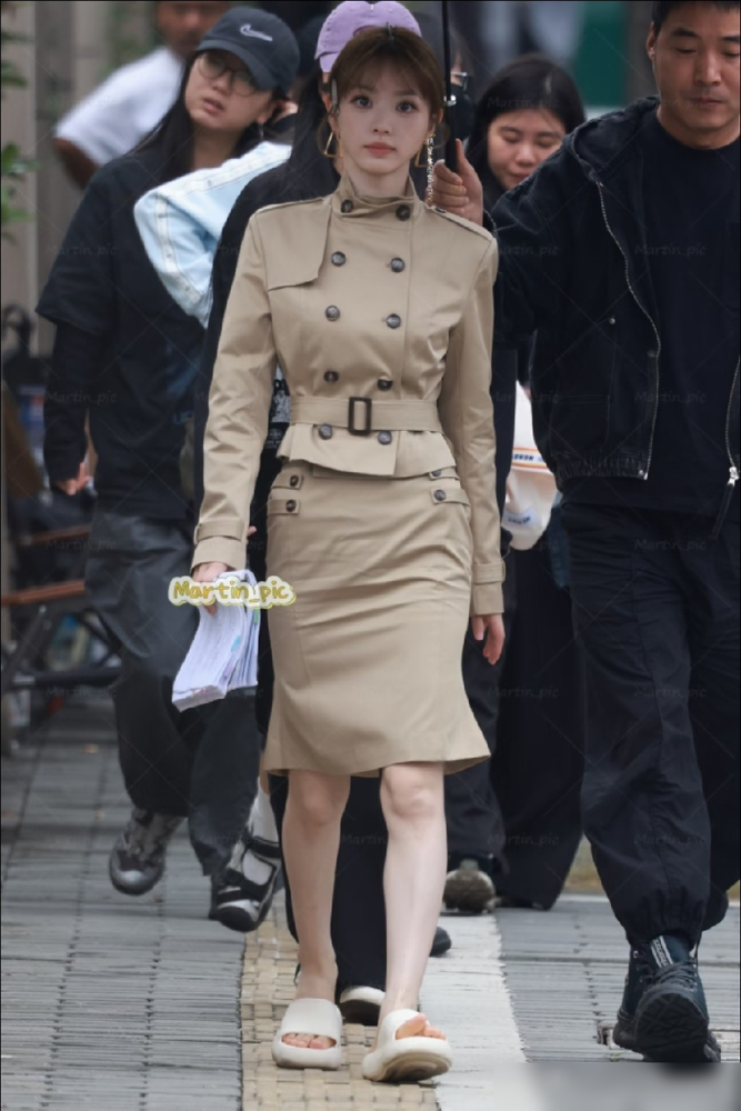 田曦薇路透里那件卡其色风衣裙，裙长直接卡在膝盖上十公分。网友吵翻了，有人截图量比例，说她五五分，有人