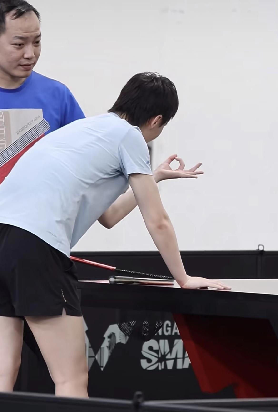 WTT新加坡大满贯比赛，训练场上古灵精怪的王曼昱。对着任浩教练比“OK”手势，