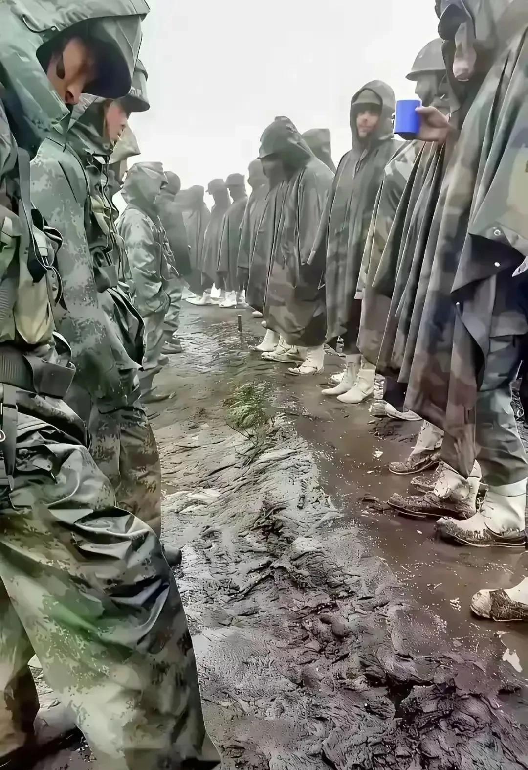 双方的士兵都披着军用雨衣，雨衣里面肯定是披挂着武器弹药的。雨一直下个不停，双方都