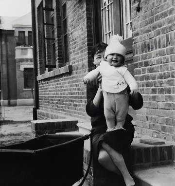 1930年，初为人母的林徽因，抱着女儿梁再冰的珍贵照片。镜头下的林徽因身着旗袍，